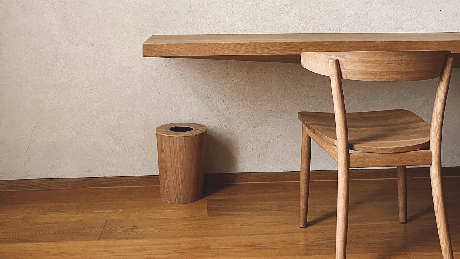A compact, well-organized apartment corner with wall shelves and a storage bench